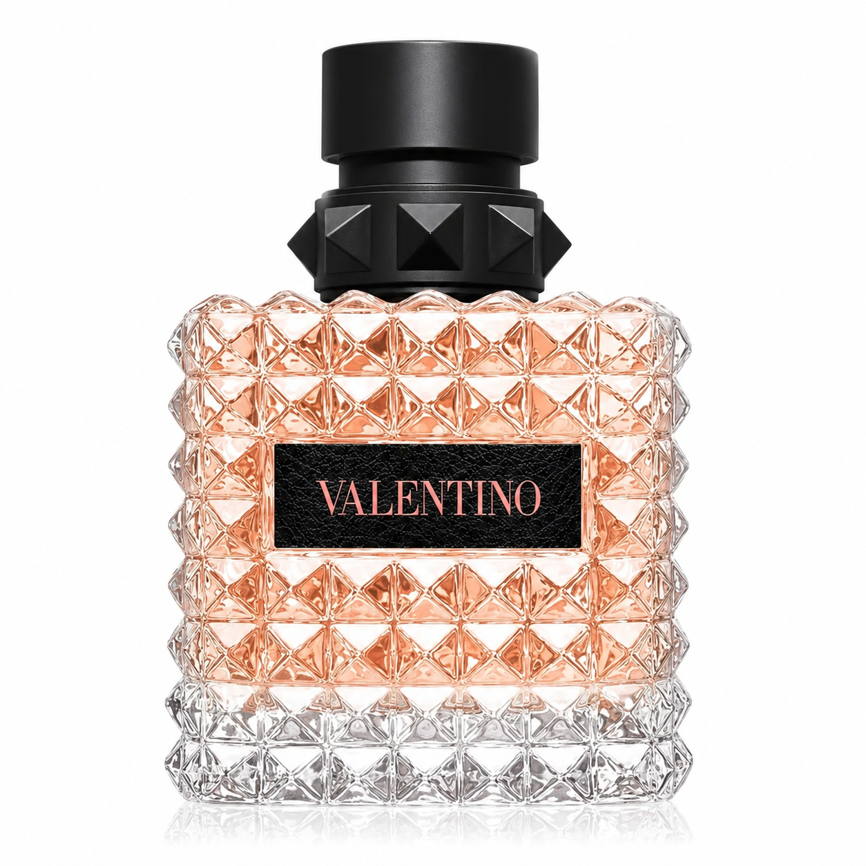 Valentino Donna Born In Roma Coral Fantasy Eau de Parfum presented in its iconic faceted glass bottle with delicate coral-pink fragrance, signature Rockstud crystal texture, elegant black studded cap and luxurious Valentino plaque. Displayed on a flawless pure white background with premium studio lighting, crystal-clear reflections, soft natural shadows and exceptional detail that highlights the bottle's couture-inspired design. A clean, elegant and photorealistic luxury e-commerce presentation.